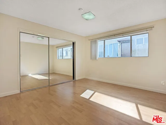 a view of an empty room with window and closet area