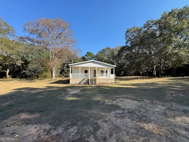 a front view of house with yard outdoor seating and barbeque oven