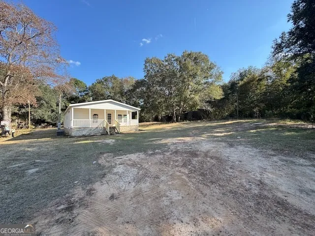 a view of dirt yard with a large tree