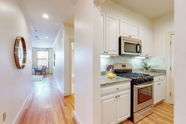 a kitchen with stainless steel appliances granite countertop a stove a sink and a microwave