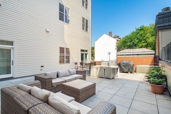 a patio with patio couch and potted plants