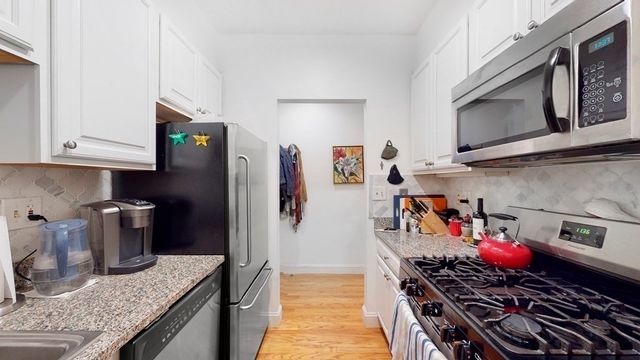 a kitchen with stainless steel appliances granite countertop a stove and a refrigerator