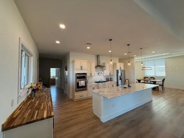 a living room with furniture kitchen view and a large window