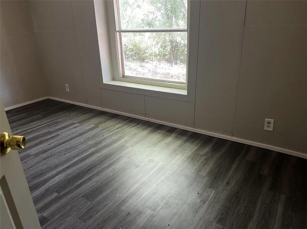 229 North 2nd Street Walnut Springs, TX 76690 - Photo 6 of 6 an empty room with wooden floor and windows