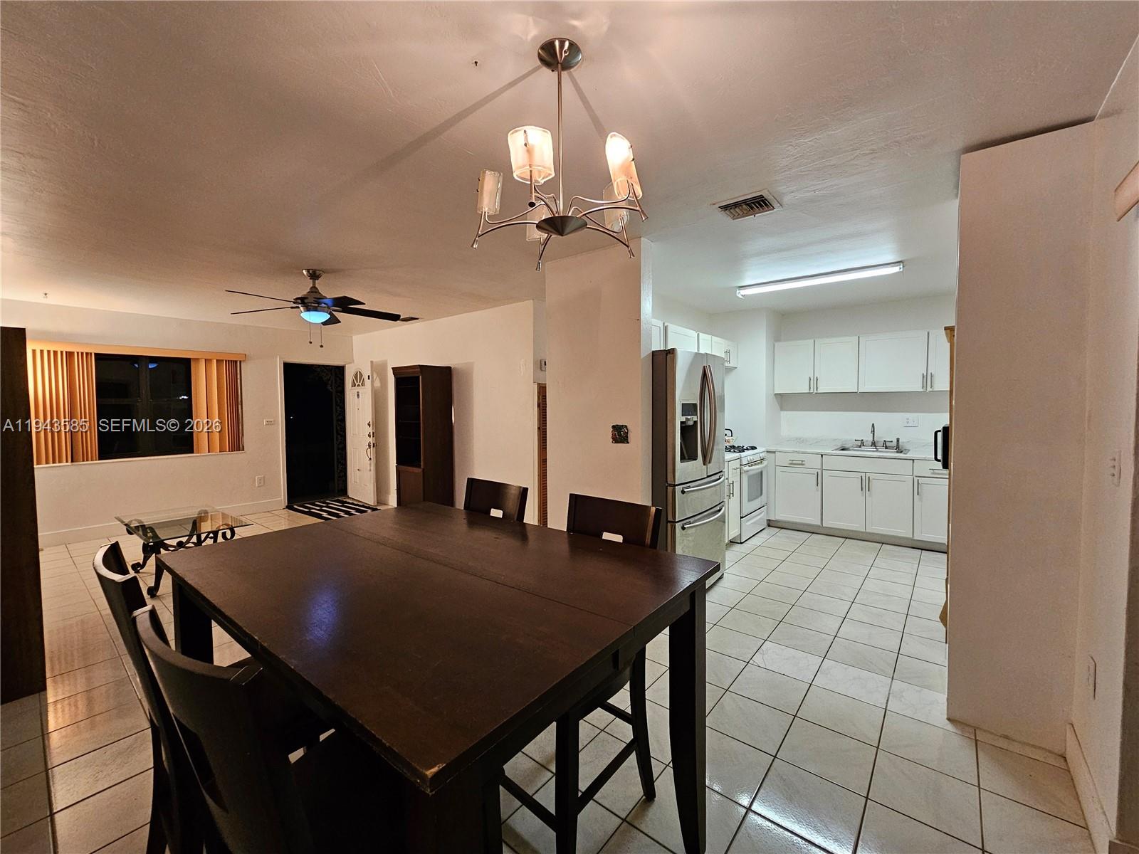 9940 Southwest 162nd Street Miami, FL 33157 - Photo 13 of 21 a view of a dining room with furniture and a chandelier