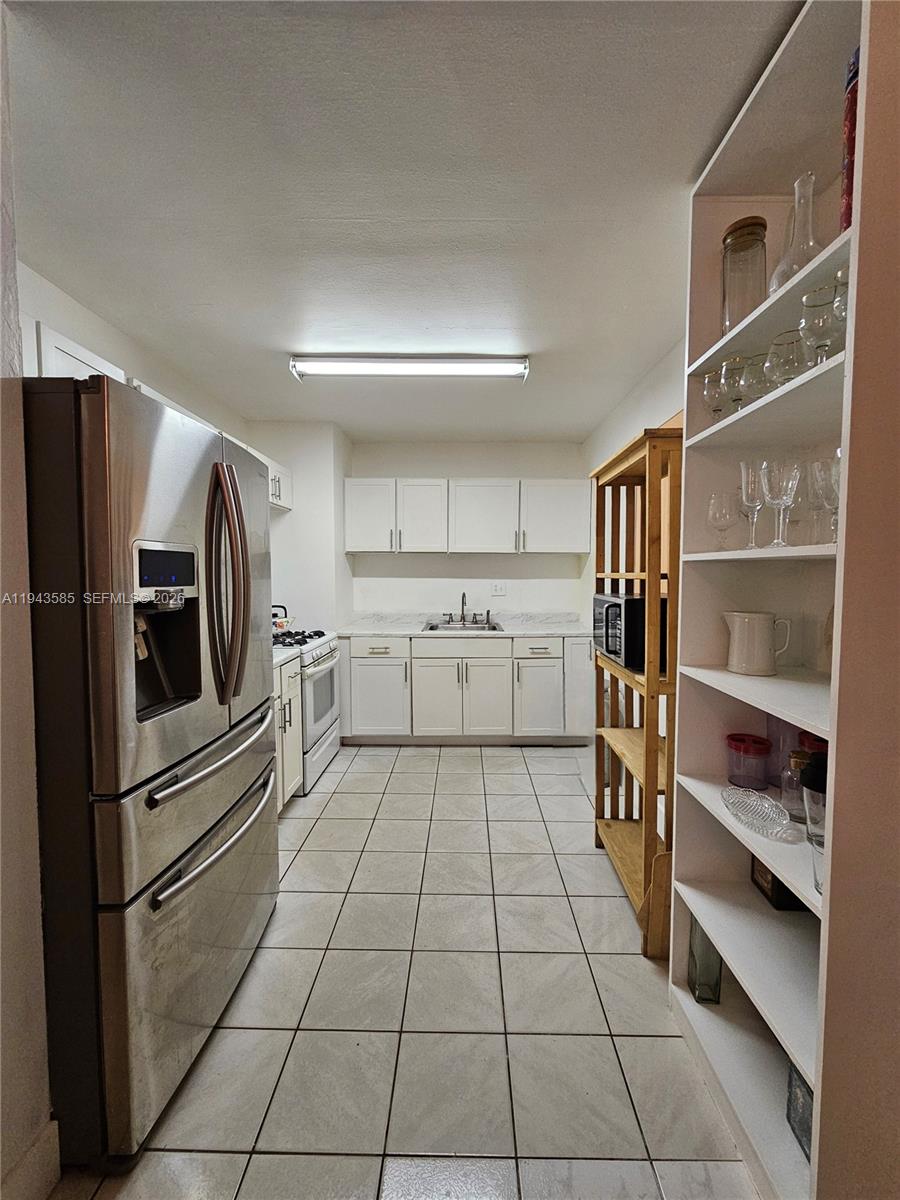 9940 Southwest 162nd Street Miami, FL 33157 - Photo 14 of 21 a kitchen with stainless steel appliances a refrigerator and cabinets
