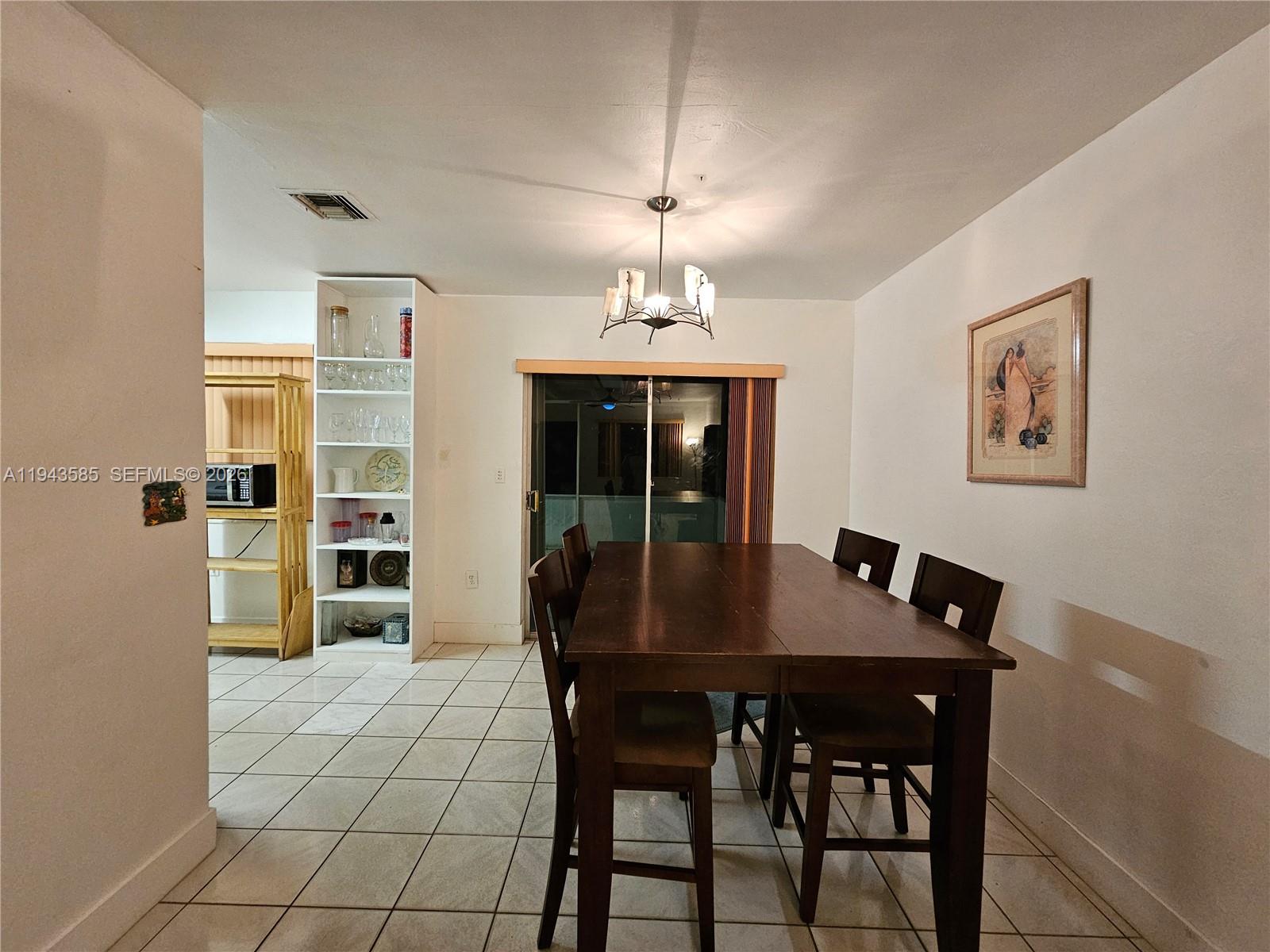 9940 Southwest 162nd Street Miami, FL 33157 - Photo 15 of 21 a view of a dining room with furniture and chandelier
