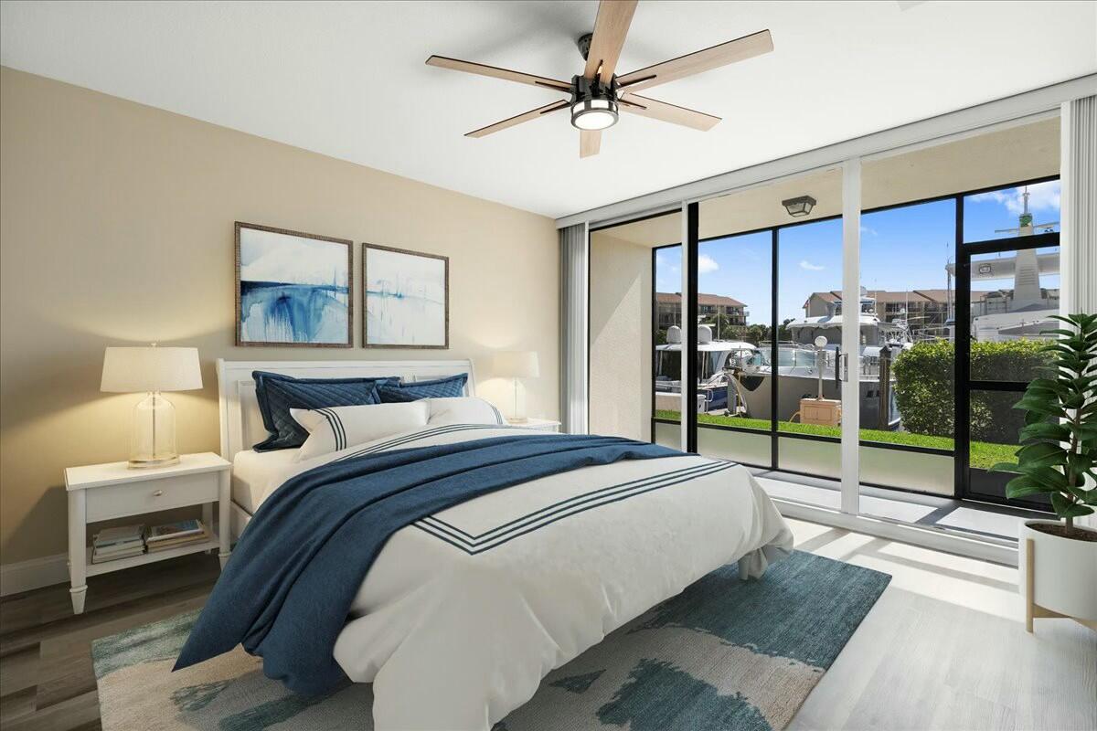 2601 Marina Isle Way, Unit 103 Jupiter, FL 33477 - Photo 19 of 56 a bedroom with a large bed and a large window