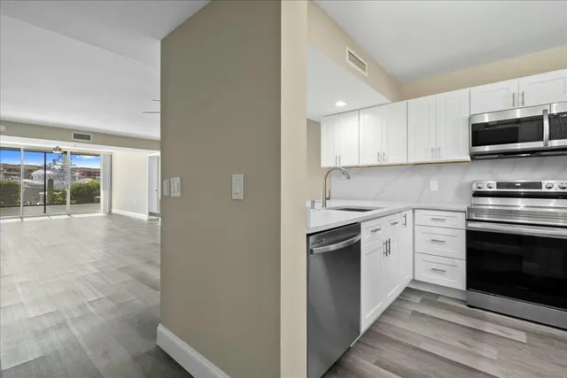 a kitchen with stainless steel appliances granite countertop a stove and a refrigerator