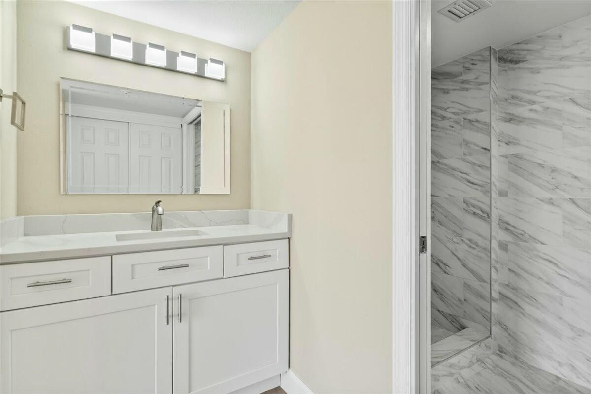2601 Marina Isle Way, Unit 103 Jupiter, FL 33477 - Photo 24 of 56 a bathroom with a sink and a mirror