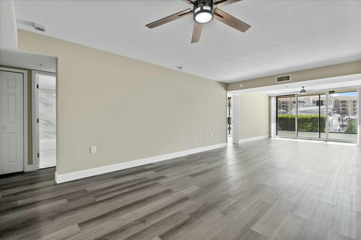 2601 Marina Isle Way, Unit 103 Jupiter, FL 33477 - Photo 10 of 56 wooden floor in an empty room with a window