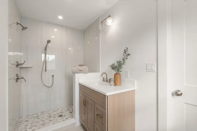 a bathroom with a shower sink and mirror