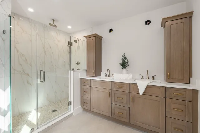 a bathroom with a double vanity sink mirror and shower
