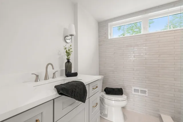 a bathroom with a toilet a sink and mirror