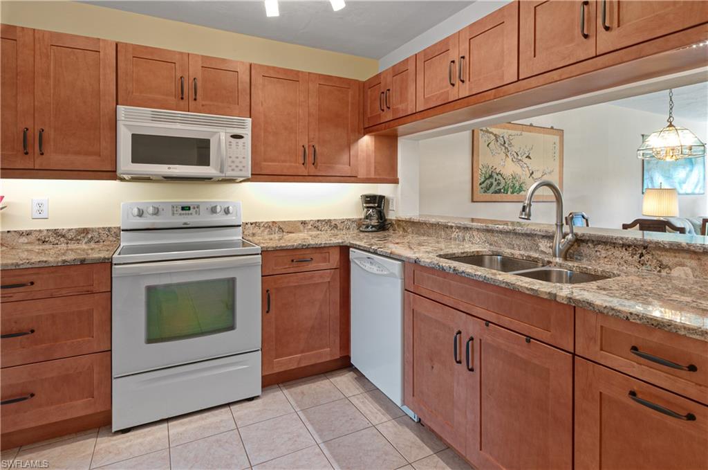 a kitchen with granite countertop cabinets stainless steel appliances and a sink