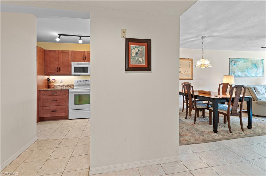 1208 Commonwealth Circle, Unit J103 Naples, FL 34116 - Photo 12 of 31 a view of a dining room with furniture and chandelier
