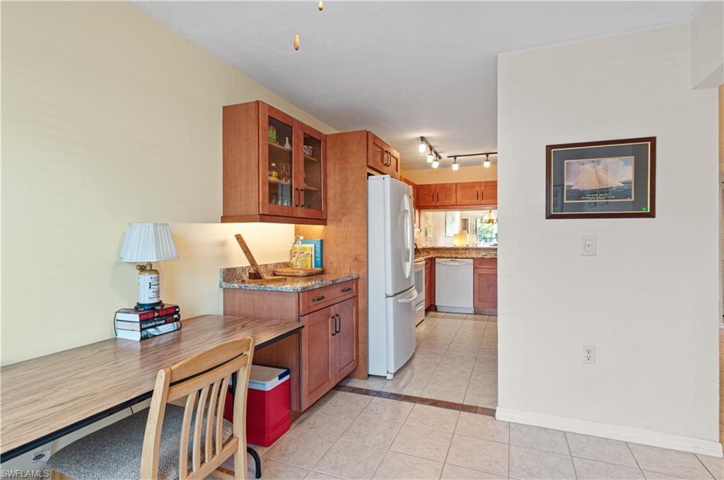 1208 Commonwealth Circle, Unit J103 Naples, FL 34116 - Photo 15 of 31 a open kitchen with stainless steel appliances granite countertop a stove refrigerator and a microwave