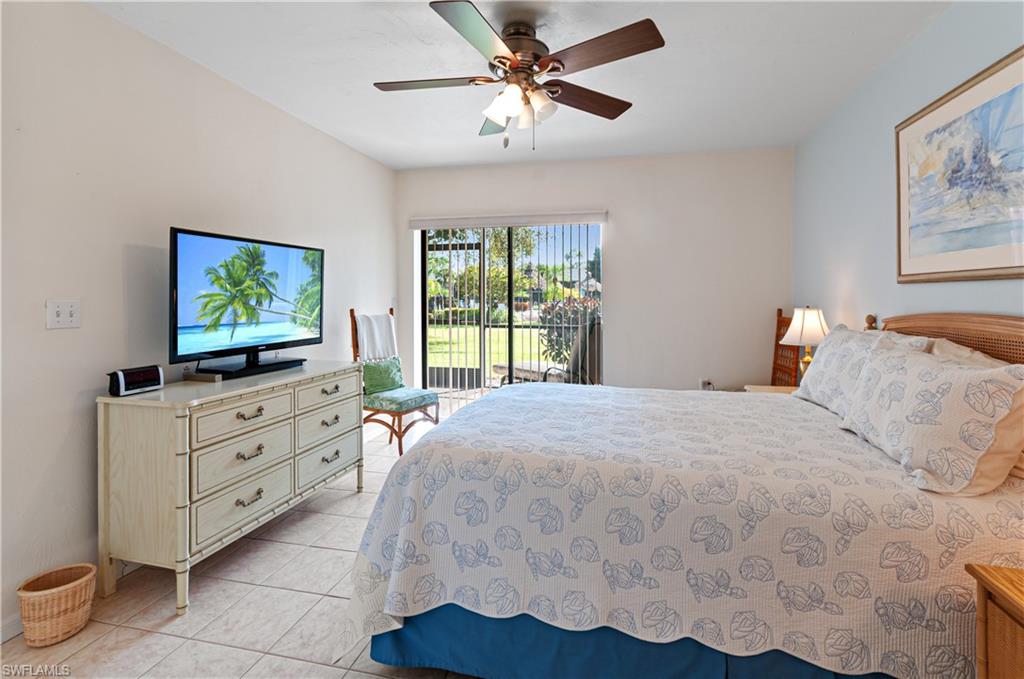 1208 Commonwealth Circle, Unit J103 Naples, FL 34116 - Photo 17 of 31 a bedroom with a bed and a flat screen tv