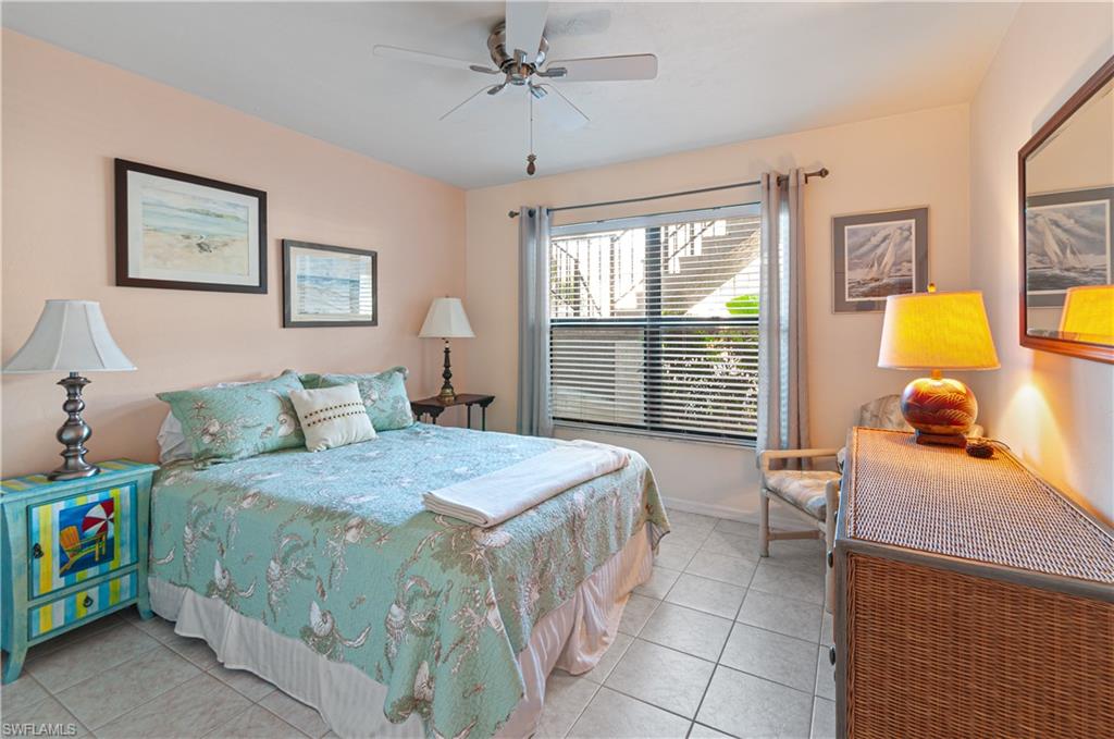 1208 Commonwealth Circle, Unit J103 Naples, FL 34116 - Photo 19 of 31 a bedroom with a bed and wooden floor
