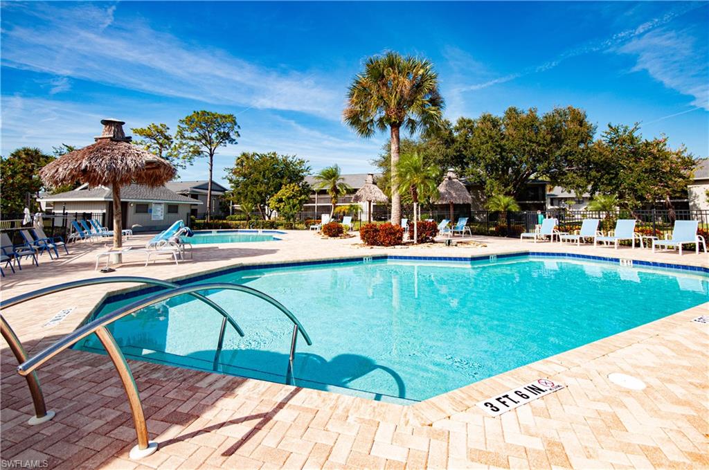 1208 Commonwealth Circle, Unit J103 Naples, FL 34116 - Photo 27 of 31 a view of a swimming pool with a garden