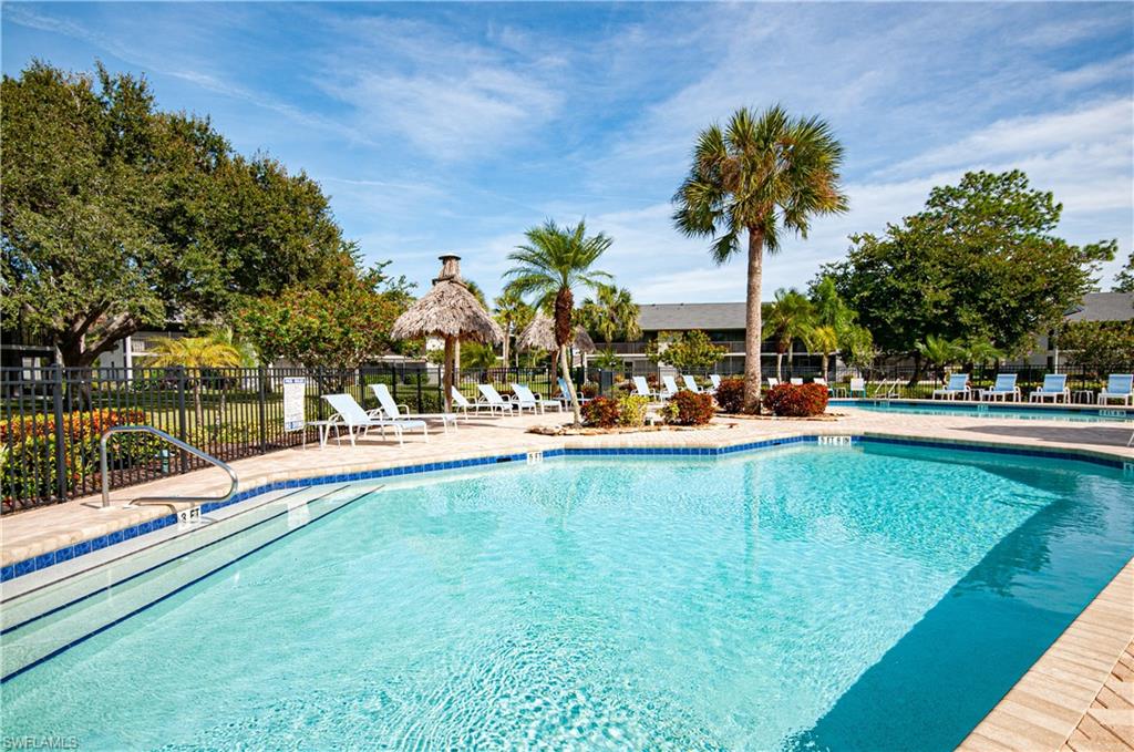 1208 Commonwealth Circle, Unit J103 Naples, FL 34116 - Photo 29 of 31 a swimming pool with outdoor seating and yard