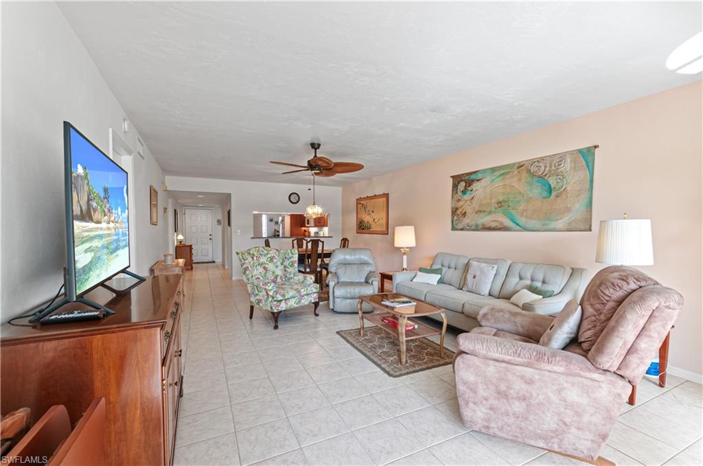 1208 Commonwealth Circle, Unit J103 Naples, FL 34116 - Photo 7 of 31 a living room with furniture and a flat screen tv