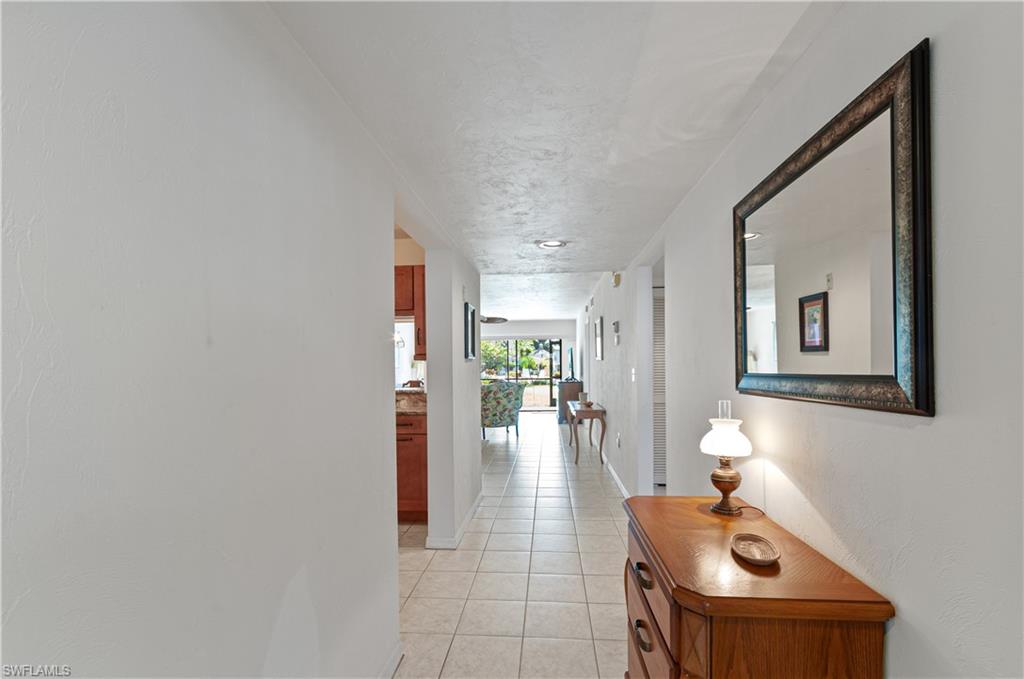 1208 Commonwealth Circle, Unit J103 Naples, FL 34116 - Photo 8 of 31 a hallway with a couch and chandelier