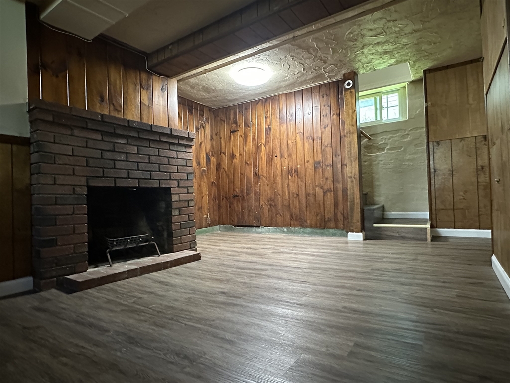 177 Johnson Street Springfield, MA 01108 - Photo 19 of 23 an empty room with wooden floor and fireplace