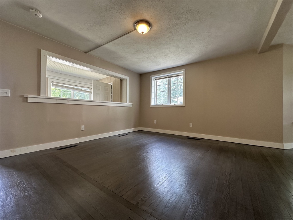 177 Johnson Street Springfield, MA 01108 - Photo 5 of 23 an empty room with wooden floor and windows
