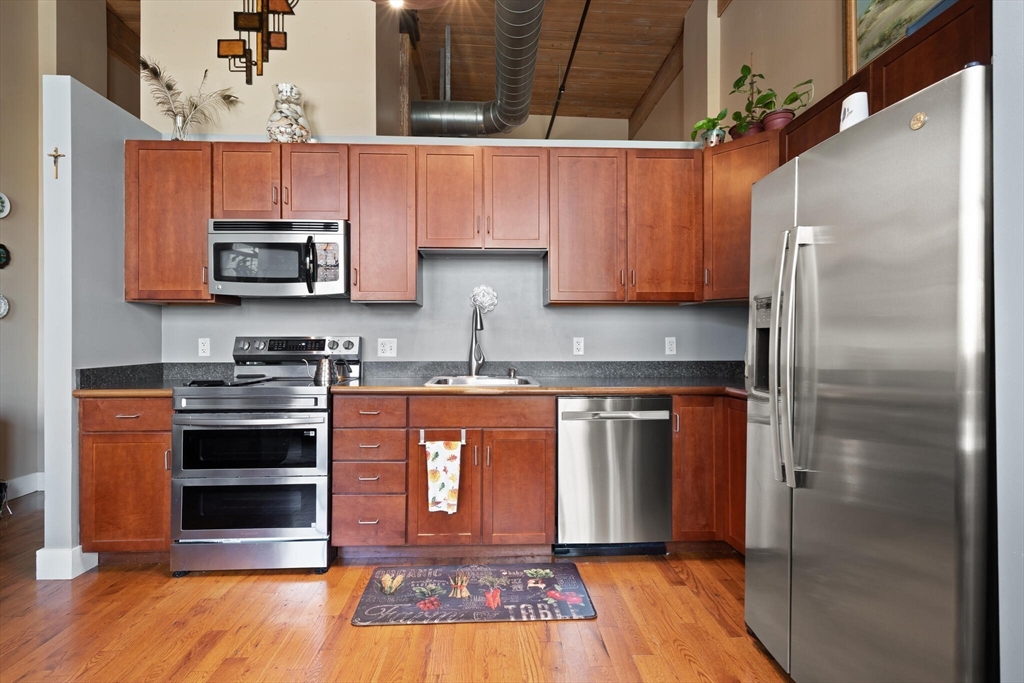 99 Allen Street, Unit 205 Woonsocket, RI 02895 - Photo 24 of 37 a kitchen with stainless steel appliances granite countertop a stove and a refrigerator