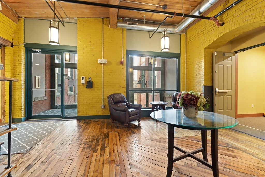 99 Allen Street, Unit 205 Woonsocket, RI 02895 - Photo 3 of 37 a living room with couches a dining table and chairs with wooden floor