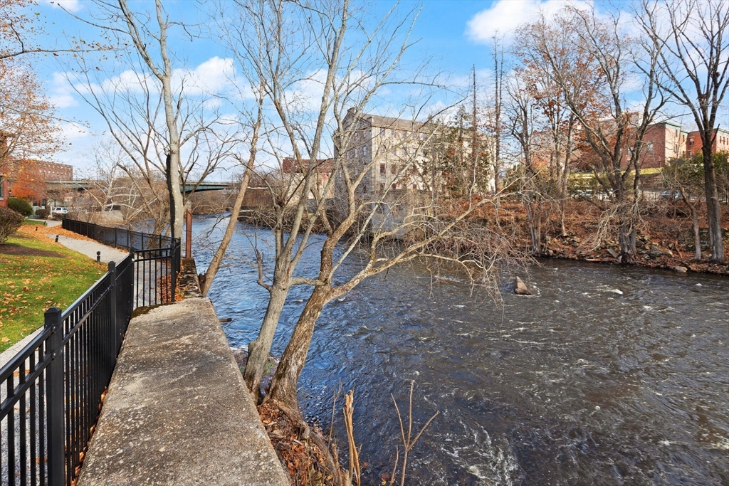 99 Allen Street, Unit 205 Woonsocket, RI 02895 - Photo 35 of 37 a view of a pathway with a wrought fence