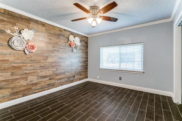 a view of an empty room with a window and a ceiling fan