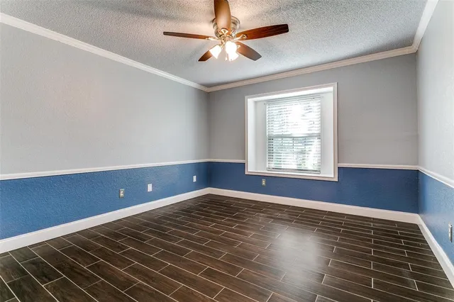 a view of an empty room with window and chandelier fan