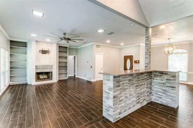 a view of kitchen with granite countertop cabinets and fireplace