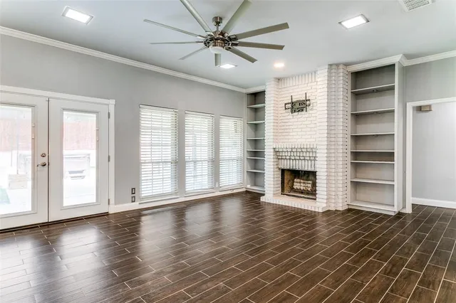 a view of a livingroom with a fireplace window and wooden floor
