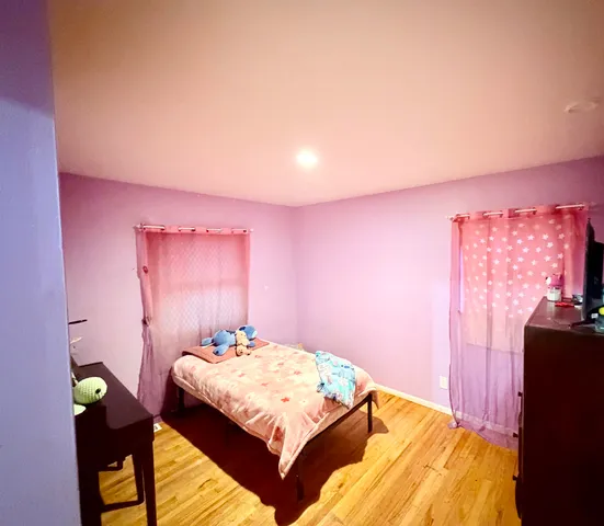 a bedroom with a bed dresser and a chair