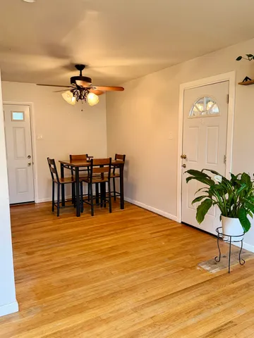 a view of a room with wooden floor dining table and chairs