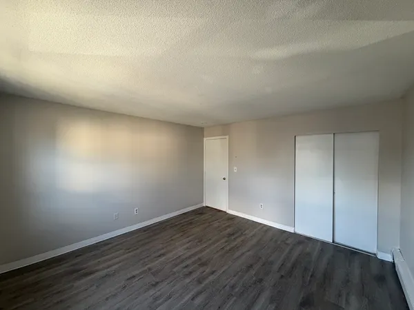 a view of an empty room and wooden floor