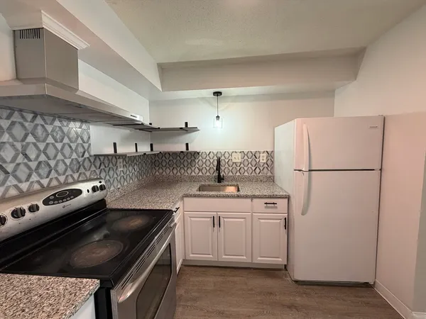 a kitchen with a stove sink and refrigerator
