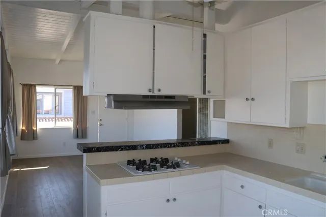 a kitchen with white cabinets and sink