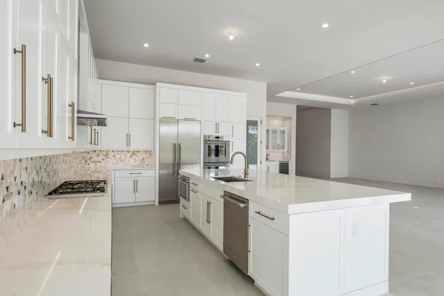 a kitchen with stainless steel appliances a sink stove and refrigerator