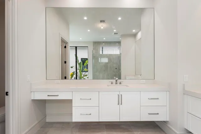 a bathroom with a granite countertop sink a toilet and shower