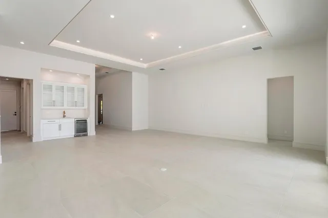 an empty room with a cabinet and mirrors