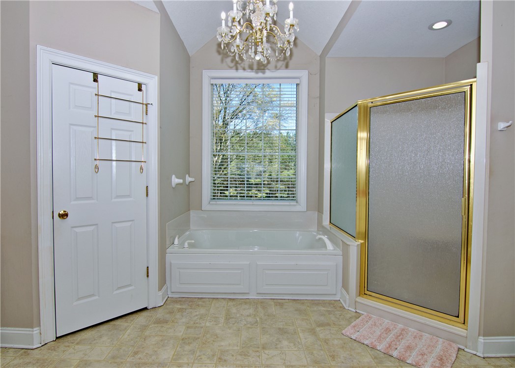 7893 Athens Road Carnesville, GA 30521 - Photo 19 of 50 This primary bathroom offers a bright space, featuring a built-in tub and separate shower.