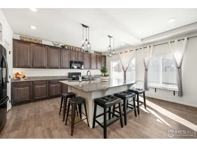 a kitchen with a table chairs a sink dishwasher window and cabinets