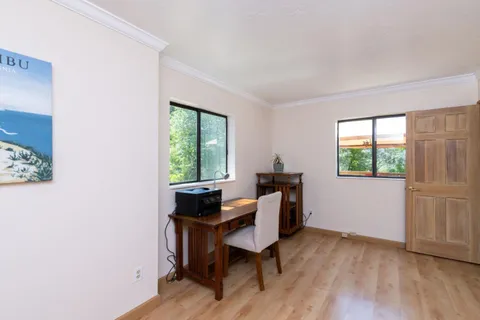 a view of a workspace with furniture and a window