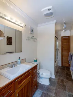 a bathroom with a sink a toilet a mirror and shower