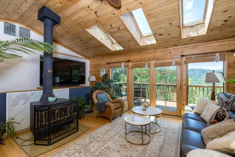 a living room with furniture a flat screen tv and a floor to ceiling window