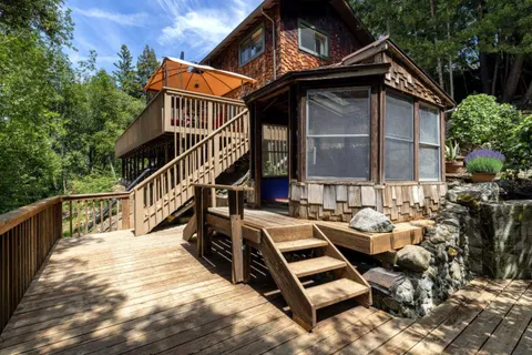 a view of a house with pool and wooden stairs